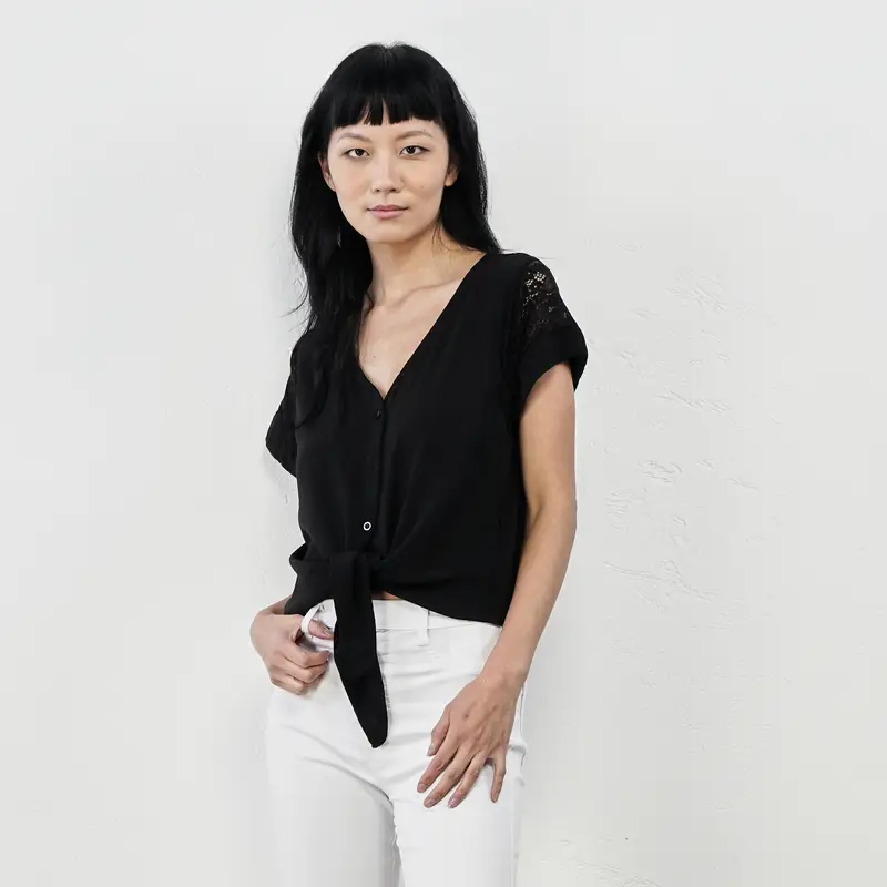 Blusa nera con fiocco e maniche con pizzo