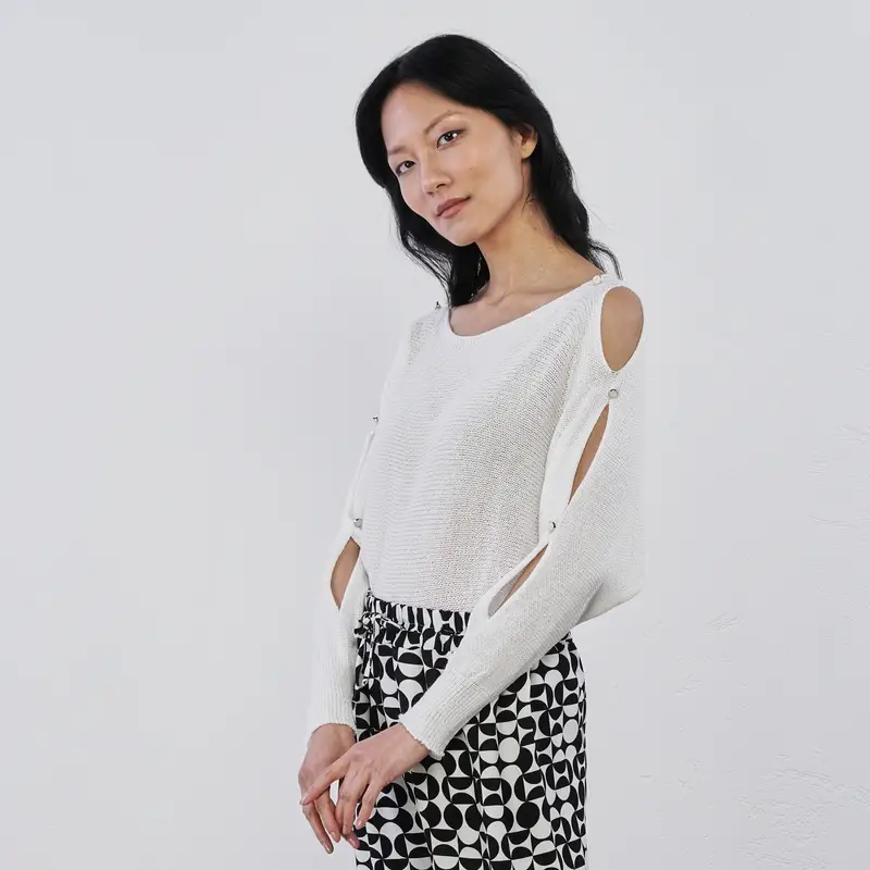 Maglioncino bianco da donna con aperture laterali e bottoni gioiello