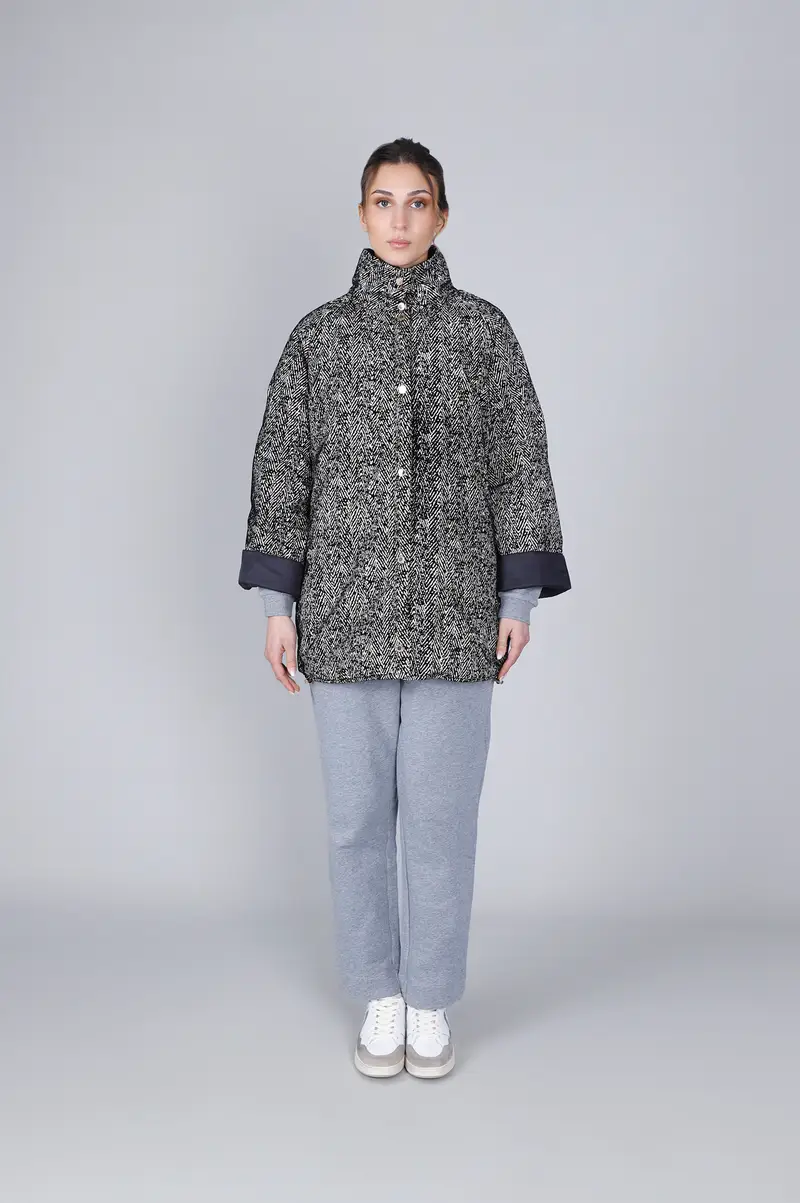 piumino tipo cappa svasata con stampa chervon avena/nero