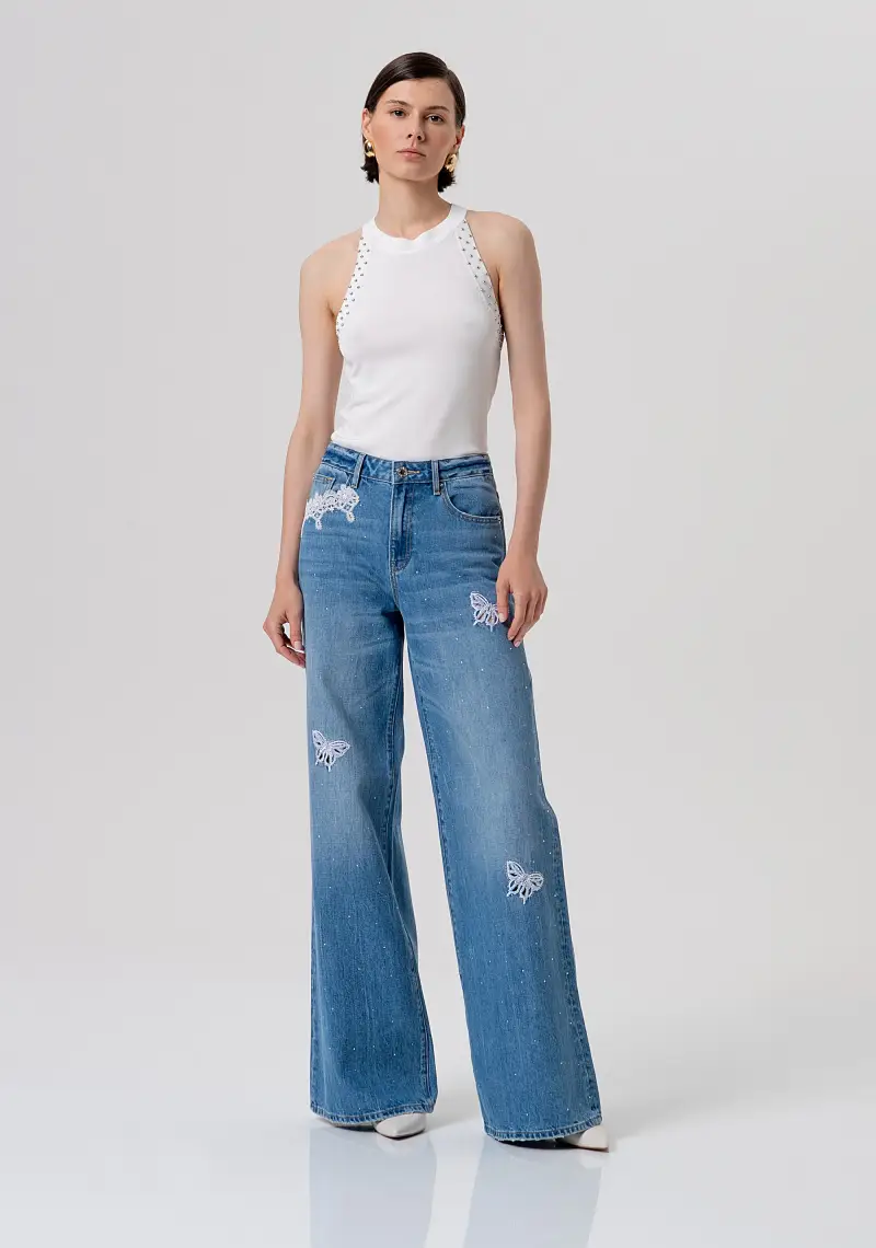 Jeans flare wide leg in denim con lavaggio medio, patch ricamati e strass