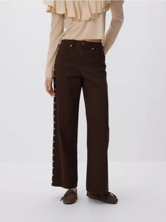 Jeans a gamba larga con applicazione - marrone